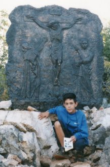 A young pilgrim visits the Stations of the Cross.